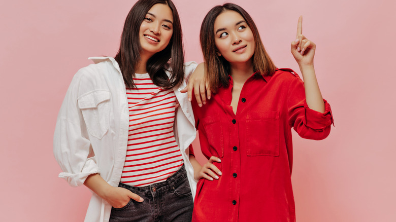 two Asian girls wearing oversized shirts