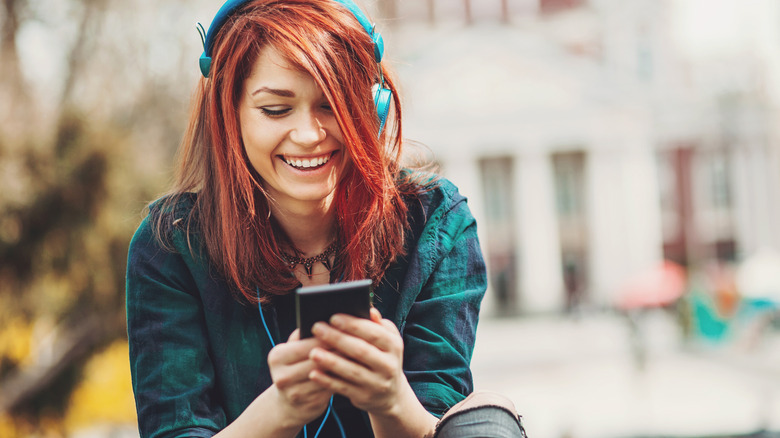 Redhead woman listening to headphones