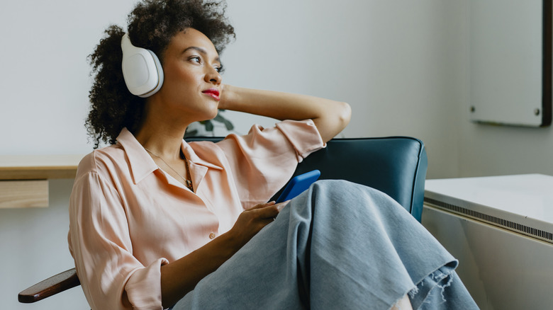 Thoughtful woman listening to headphones