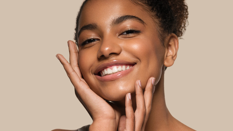 A smiling woman wearing nude lipstick