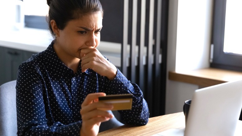 Woman frowning at credit card