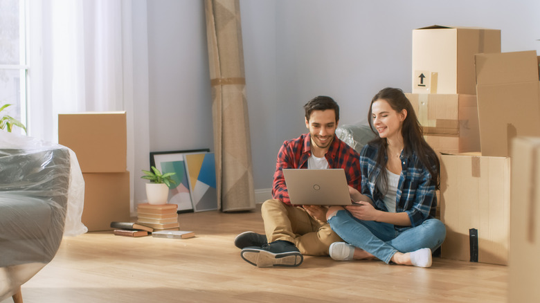 Couple sitting with boxes in new house