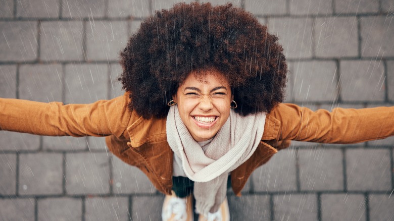 Woman standing in rain and laughing