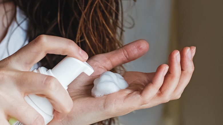 Person using hair mousse