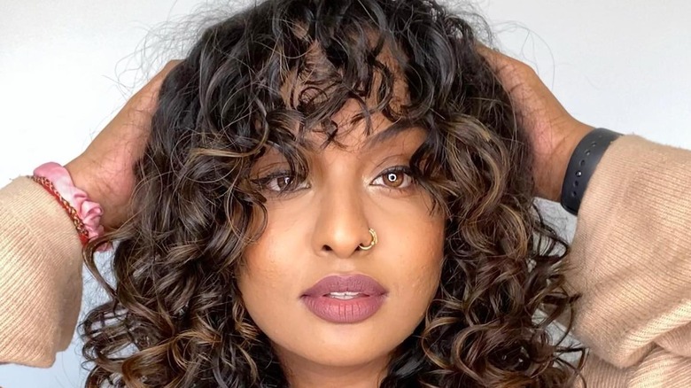 Woman with curly hair and bangs