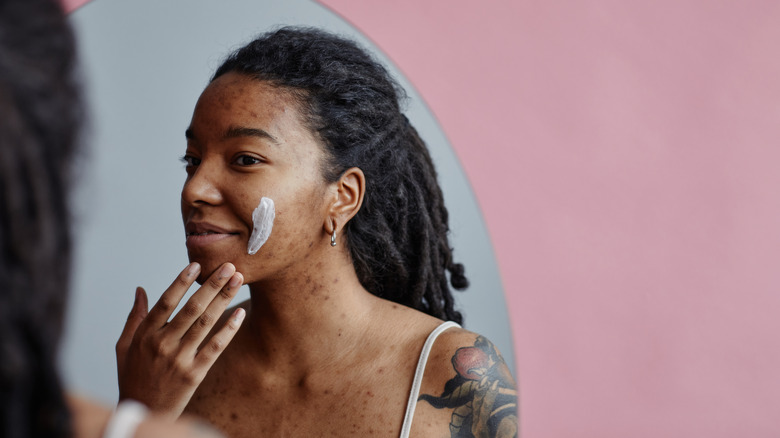 A woman applying moisturizer