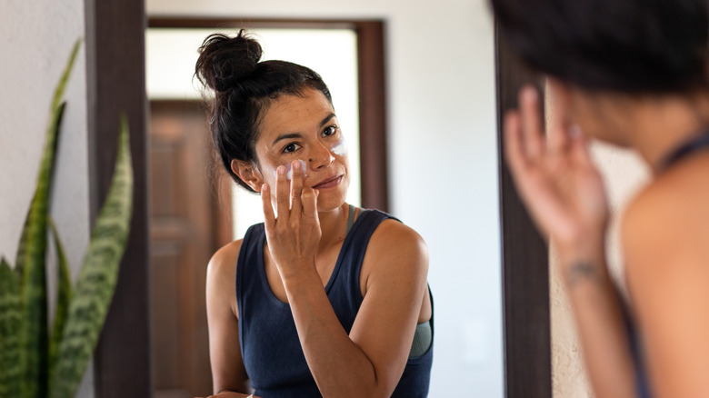 A woman applying moisturizer