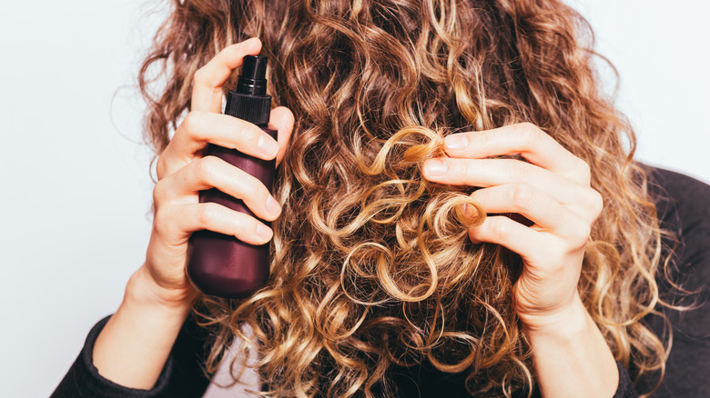 Woman spraying hair mist 