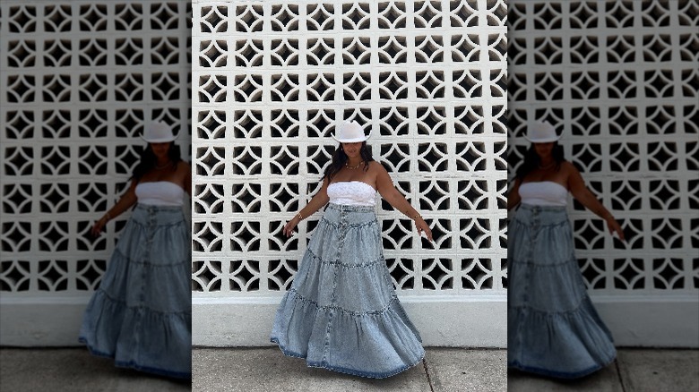 Woman wearing a denim maxi skirt and tube top.