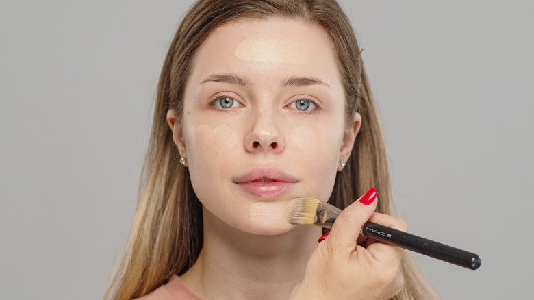 woman applying makeup on face