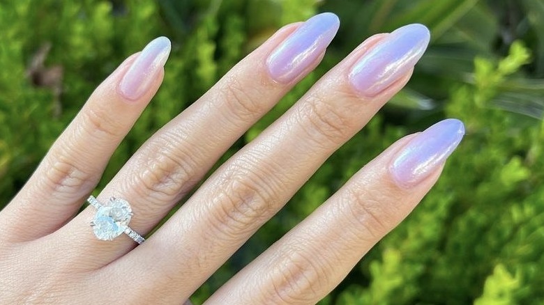 hand wearing ring and pearlescent manicure