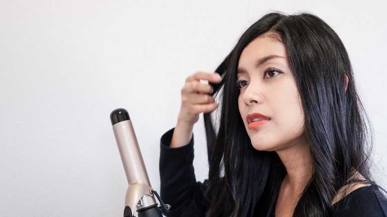 Woman prepares to use curling iron