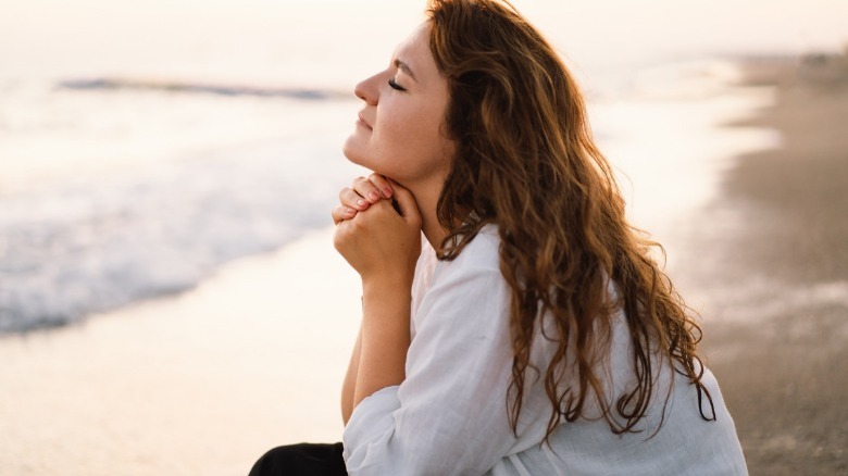 woman praying by the sea