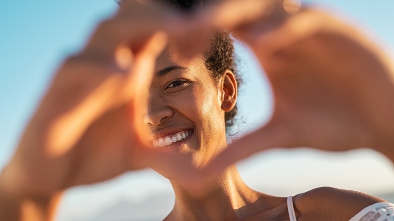 happy woman making heart signal