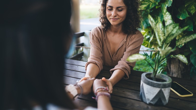 Woman holding friend's hands