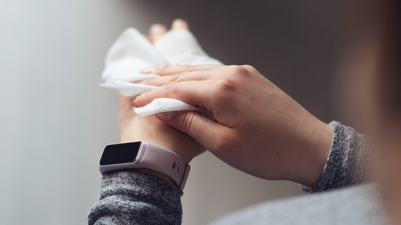 Person cleaning a hand with alcohol wipe