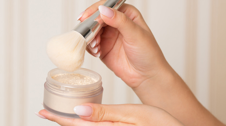 Brush poised over makeup powder