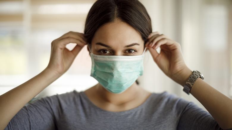 A woman putting on a mask