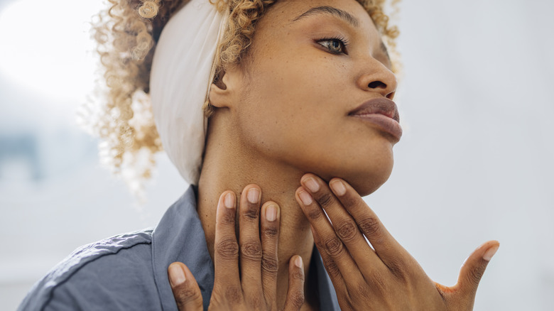 Woman putting on face cream.