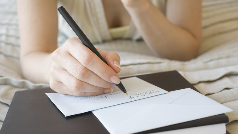 woman writing on envelope