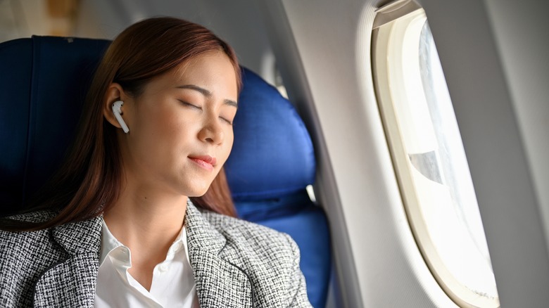 Asian woman relaxing on airplane