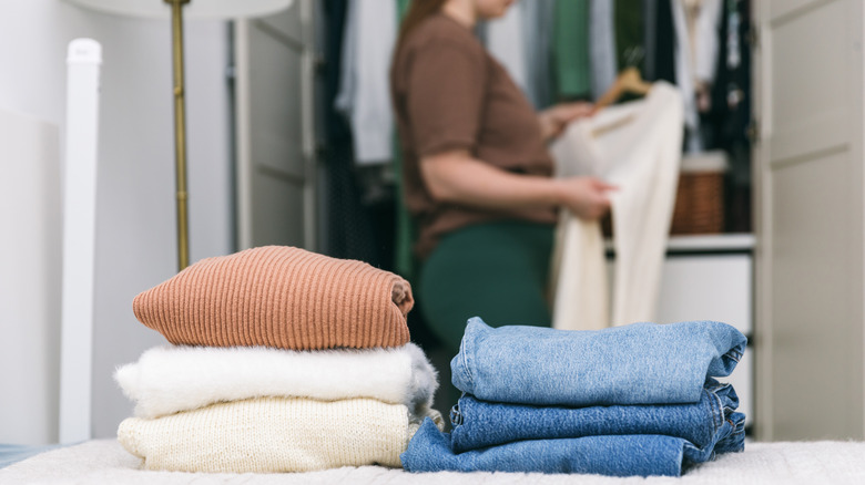 Woman storing folded clothes