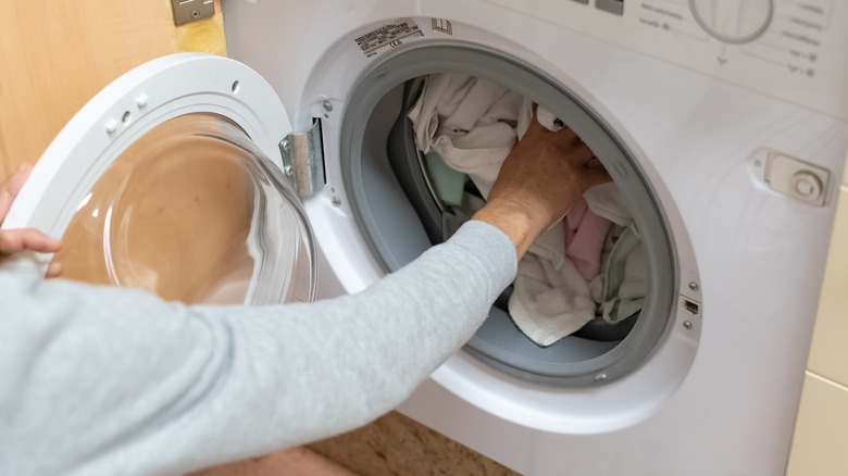 person loading washing machine