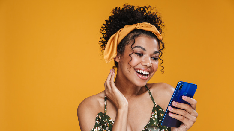 woman wearing headband looking at phone