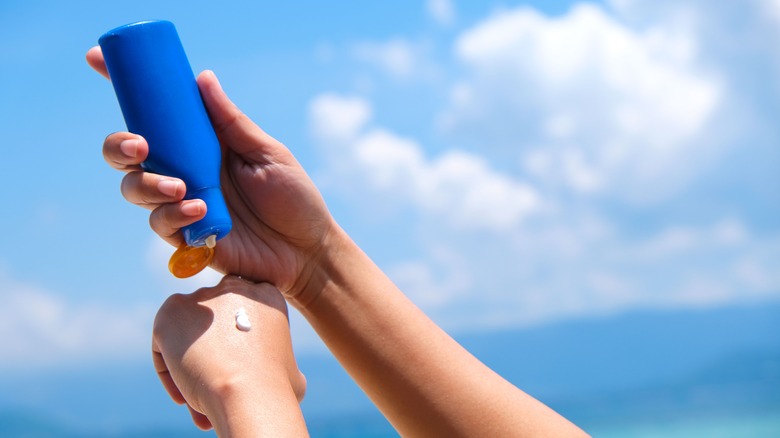 Woman applying sunscreen at the beach