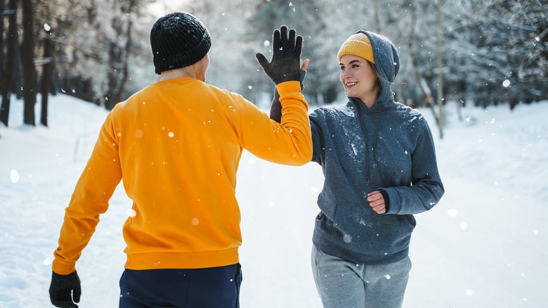 Couple high fiving in snow