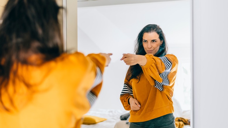 Woman smiles in mirror 