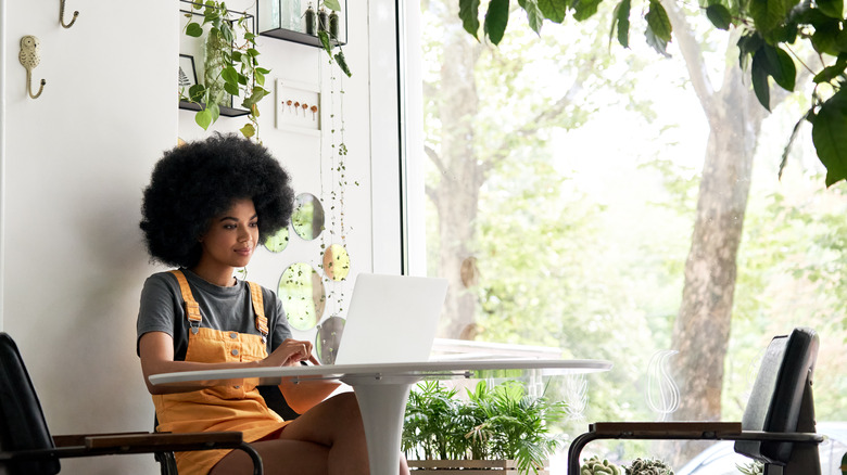 Woman working near window on computer