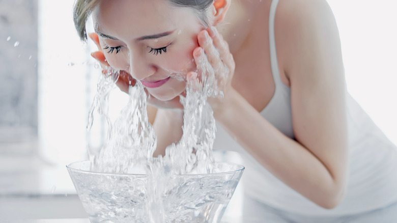 Woman splashing face with water