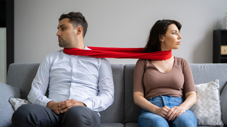 couple connected by red scarf