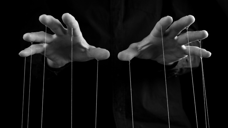 hands holding puppet strings