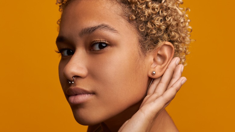 Black woman touching stud earring