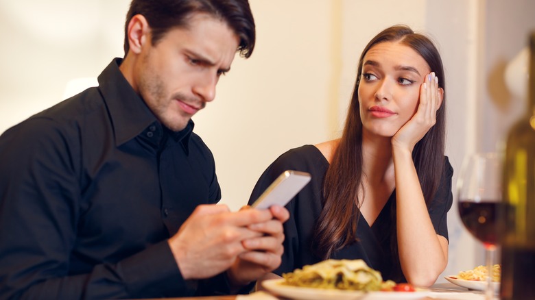 person on phone during date
