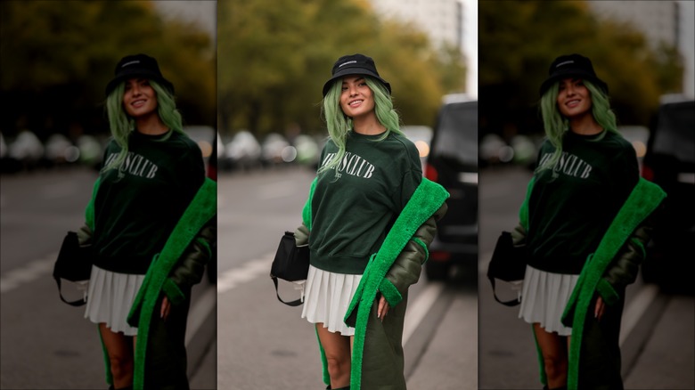 woman wearing sweatshirt and tennis skirt