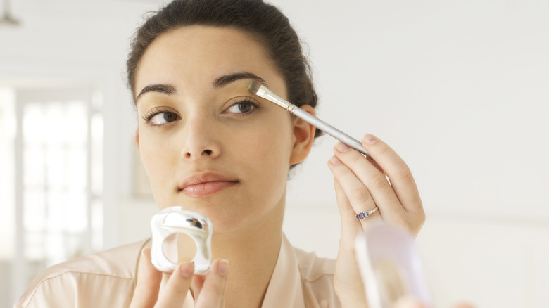 Woman applying nude eyeshadow