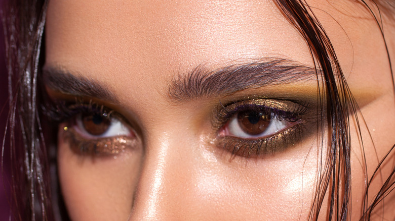 Model wearing green reverse cat eye makeup