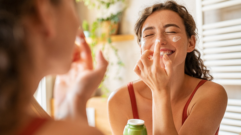 Woman moisturizing face 