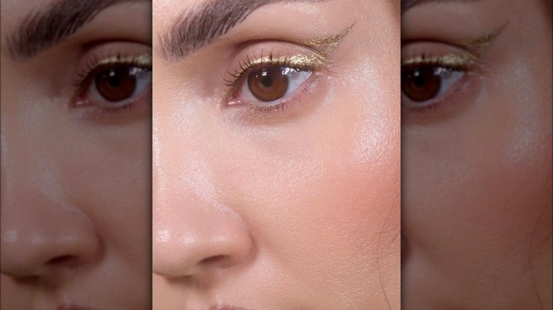 A woman with gold eyeliner