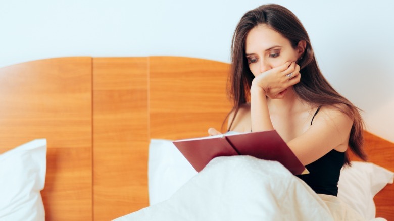 Woman journaling in bed