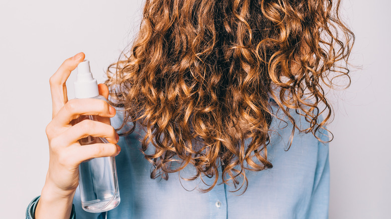 woman spraying sea salt in her hair