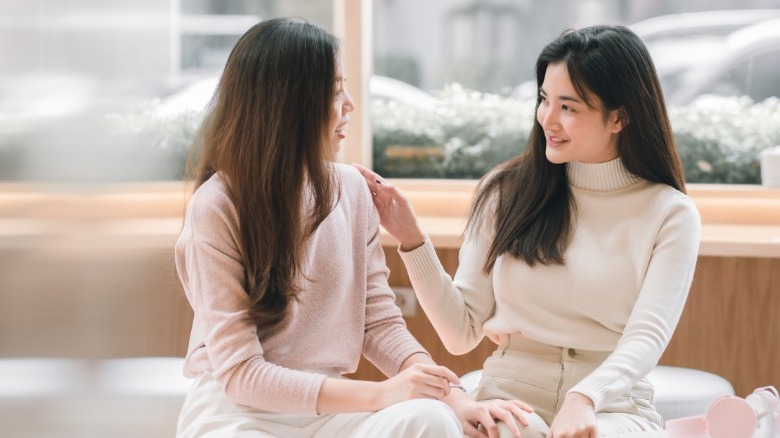 Two women talking and touching