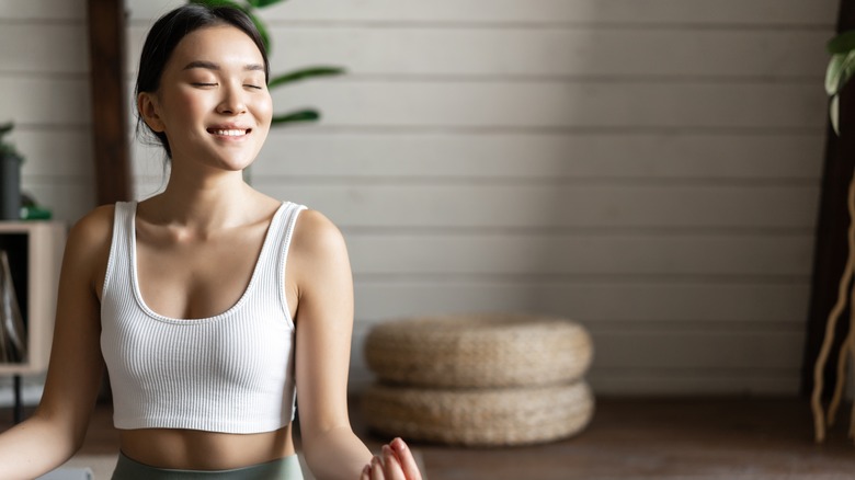 asian woman smiling while in a yoga pose