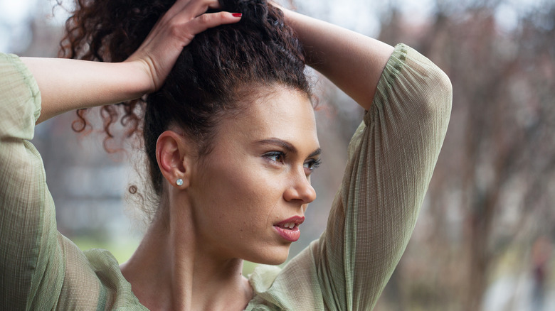 A woman tying her hair up