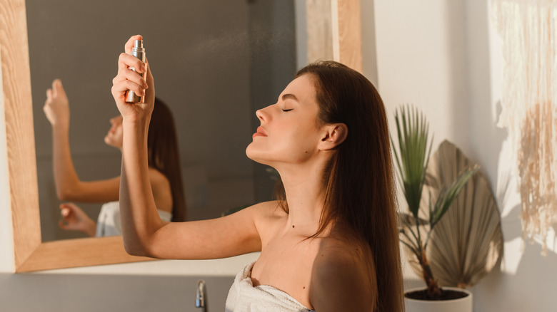 Woman in bathroom misting face