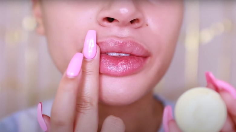 woman applying lip balm mask