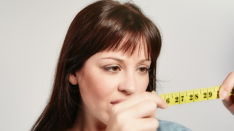 Woman holding up a measuring tape